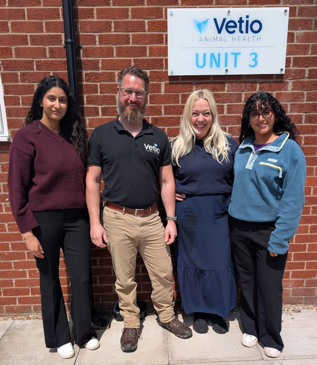 Four members of the AniVatio and Vetio teams standing together outside Vetio Animal Health's Unit 3, beneath the Vetio sign